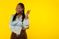 Cheerful Black Lady Pointing Finger Aside On Yellow Studio Background Royalty Free Stock Photo