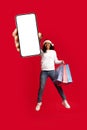 Cheerful black lady shopaholic showing nice offer on smartphone Royalty Free Stock Photo