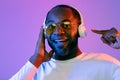 Cheerful black man using wireless headphones, pointing at gadget Royalty Free Stock Photo