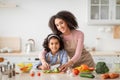 Cheerful black mom teaching daughter how to prepare salad Royalty Free Stock Photo