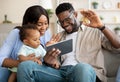 Happy black family having videocall using tablet waving hands Royalty Free Stock Photo