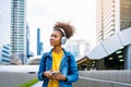 Cheerful black student girl wearing headset and using mobile smartphone Royalty Free Stock Photo