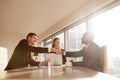 Cheerful black and white businessmen shaking hands at multi-ethn Royalty Free Stock Photo