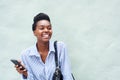 Cheerful black woman holding cell phone