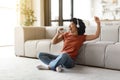 Cheerful black woman listening music in headphones and singing at home Royalty Free Stock Photo