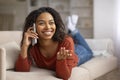 Cheerful Black Woman Talking On Cellphone At Home While Lying On Couch Royalty Free Stock Photo