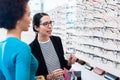 Black woman inspecting glasses in optician shelf Royalty Free Stock Photo