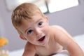 Cheerful blond baby on a bed