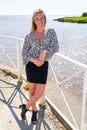 Cheerful blond slim young woman on water beach aside port beach