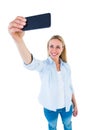 Cheerful blonde taking a selfie with smartphone