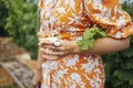 Cheerful blonde woman in bright orange dress with floral print holds glass of champagne Royalty Free Stock Photo