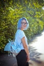 Cheerful blue-haired girl student with a briefcase of silver material