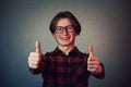 Cheerful boy adolescent showing double thumbs up, positive gesture, great feedback and approval, looking to camera with teeth Royalty Free Stock Photo