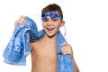 Cheerful boy, with blue swimming goggles on his head and with a blue towel on his shoulders, laughs, concept, on a white Royalty Free Stock Photo