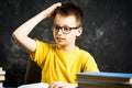 Cheerful boy with bunch of books thinking about school