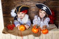 Funny boy and girl in pirate costumes in the studio with scenery for Halloween