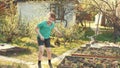 Cheerful boy having fun outdoor in slow motion. Smiling teenage boy dancing in his garden.