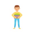 Cheerful boy holding small laundry basket with clean folded clothes. Housework and chores theme. Flat vector