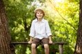 Cheerful boy in pajamas sits in the forest Royalty Free Stock Photo