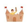 Cheerful boy playing in castle made of cardboard boxes. Little medieval prince with golden crown and sword in hand. Flat