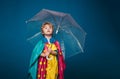 Cheerful boy in raincoat with colorful umbrella. Kid in rain. Cute little boy are preparing for autumn sunny day. Cute