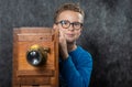 Cheerful boy retro photographer with vintage wooden camera Royalty Free Stock Photo