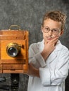 Cheerful boy retro photographer with vintage wooden camera Royalty Free Stock Photo