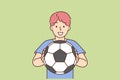 Cheerful boy of school age holding soccer ball and smiling offers to play football