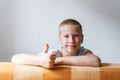 Cheerful boy showing thumbs up, portrait of a child against a wall background . Royalty Free Stock Photo