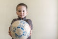 Cheerful boy with a soccer ball in his hand. Light background. European appearance. copy space