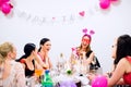 Cheerful bride and bridesmaids celebrating hen party with drinks