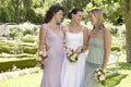 Cheerful Bride And Friends Holding Bouquets In Garden