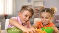 Cheerful brother and sister having fun with food, happy childhood, pranksters