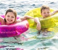 Cheerful brother and sister swimming in the pool