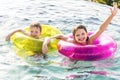 Cheerful brother and sister swimming in the pool