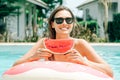 Cheerful brunette girl in a black bikini holding a watermelon in her hands and smiling Royalty Free Stock Photo