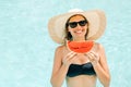 Cheerful brunette girl in a black bikini holding a watermelon in her hands and smiling Royalty Free Stock Photo