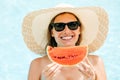 Cheerful brunette girl in a black bikini holding a watermelon in her hands and smiling Royalty Free Stock Photo