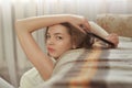 Happy brunette girl talking on mobile phone while sitting near couch Royalty Free Stock Photo