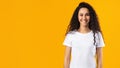 Cheerful Brunette Lady Wearing White T-Shirt Standing Over Yellow Background Royalty Free Stock Photo