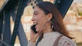 Cheerful brunette talking cell call sharing good news at iron bridge closeup