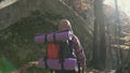 Cheerful brunette tourist man wears a shirt ina cages and backpacked have walk through forest, autumn tourism concept