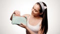 Cheerful brunette woman looking at cosmetics bag against white background Royalty Free Stock Photo