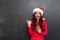 Cheerful brunette woman in red blouse and christmas hat