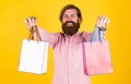 Cheerful brutal hipster hold gift. paper shopping bag. birthday surprise at party. man with package. prepare for Royalty Free Stock Photo