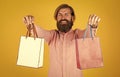 Cheerful brutal hipster hold gift. paper shopping bag. birthday surprise at party. man with package. prepare for Royalty Free Stock Photo