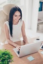 Cheerful business lady is enjoying her work at nice modern office. She is wearing smart white outfit, smiling Royalty Free Stock Photo