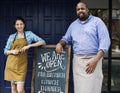 Cheerful business owners standing with open blackboard Royalty Free Stock Photo