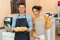 Cheerful business owners standing welcomingly together in front of the counter of their cafe