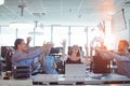 Cheerful business people tossing crumpled paper balls at desk in office